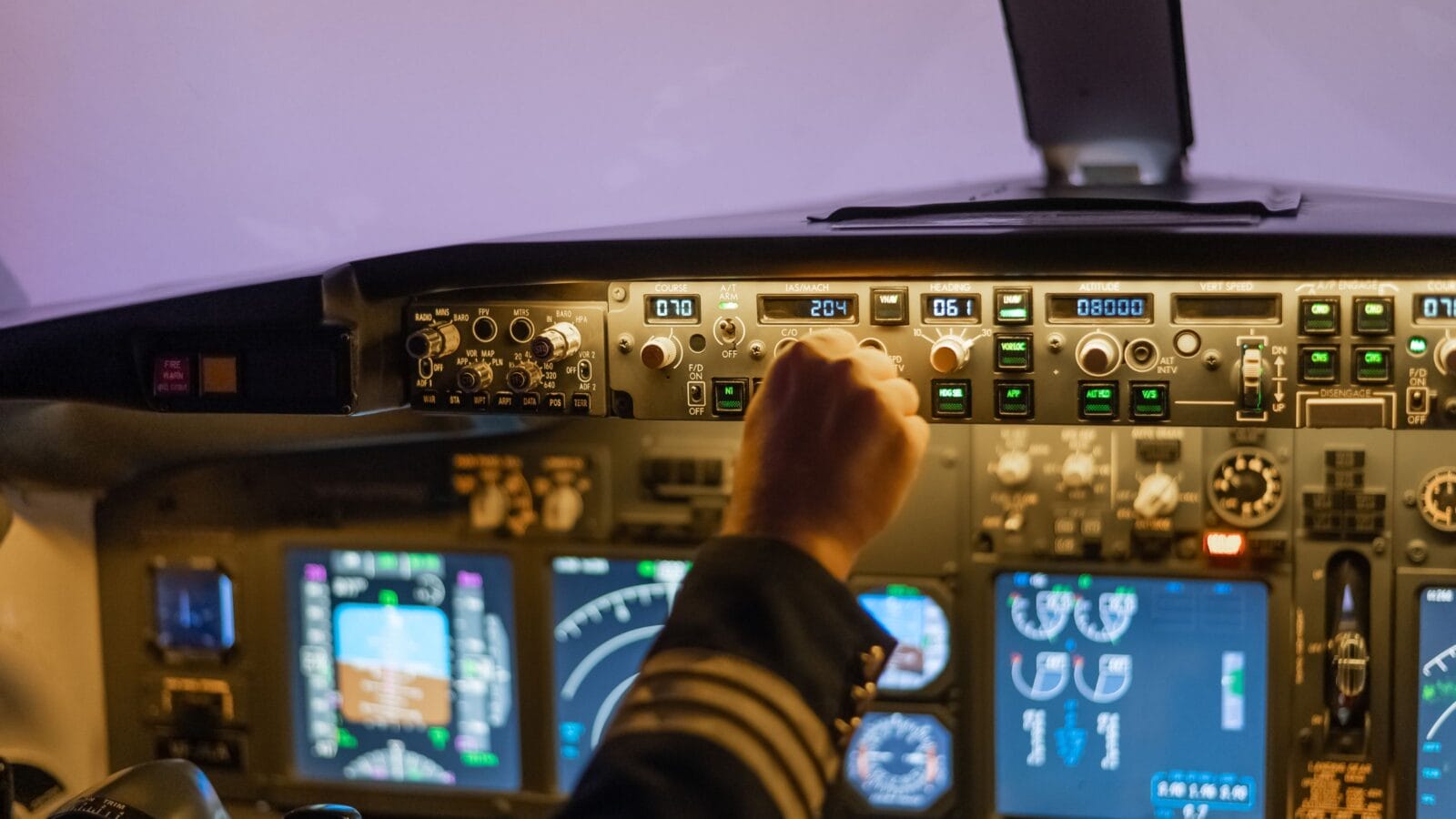 A man is studying to be a pilot in a flight simulator. Close-up of male hands on the control panel of an aircraft.