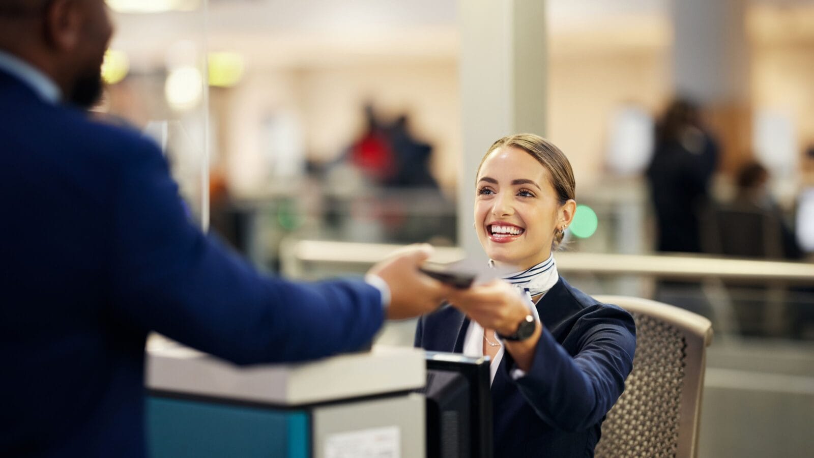 Woman, airport and service agent with passport helping traveler for check in at terminal counter.