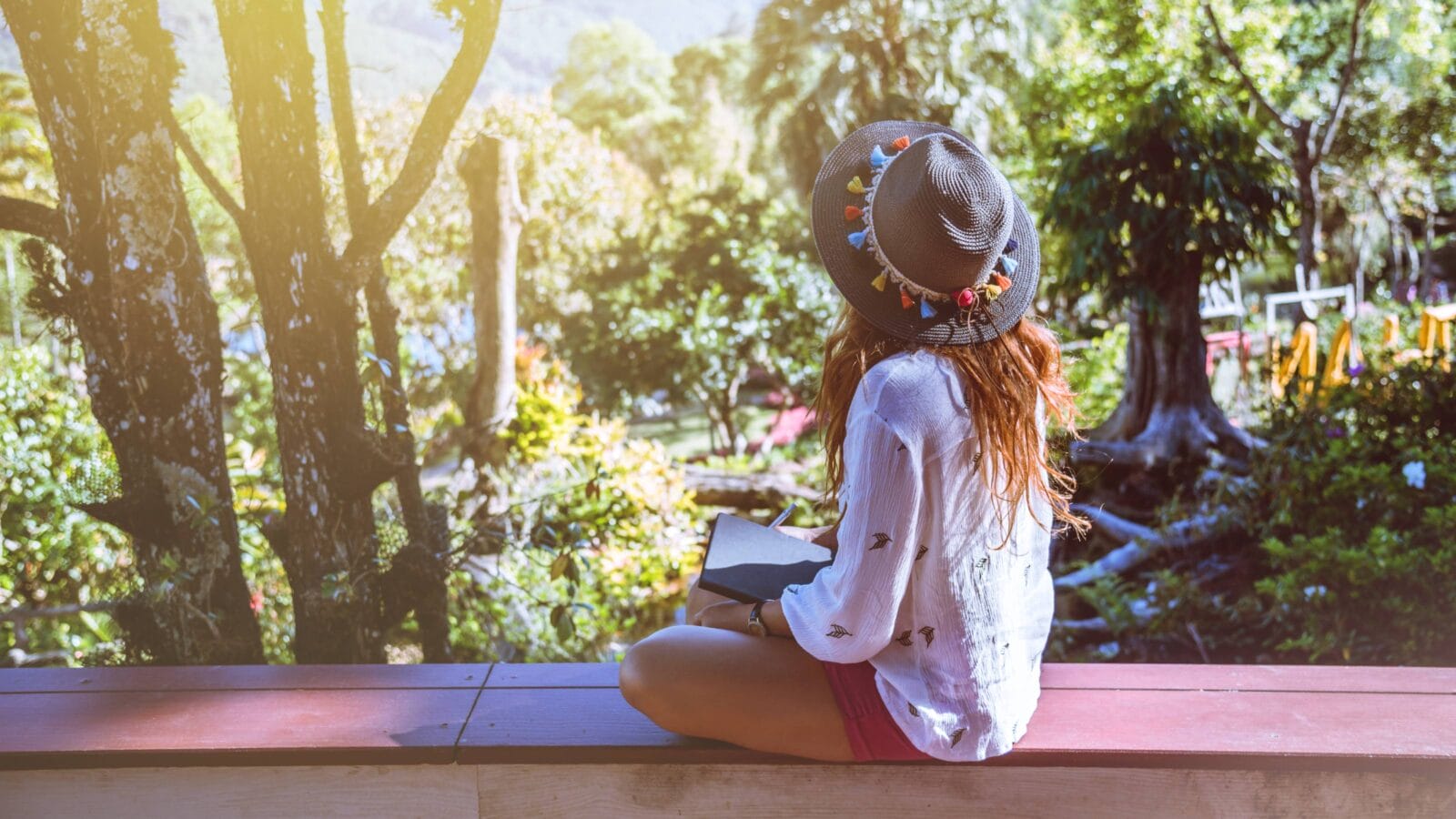Asian woman relaxin with a diary in her hands at public park in Thailand