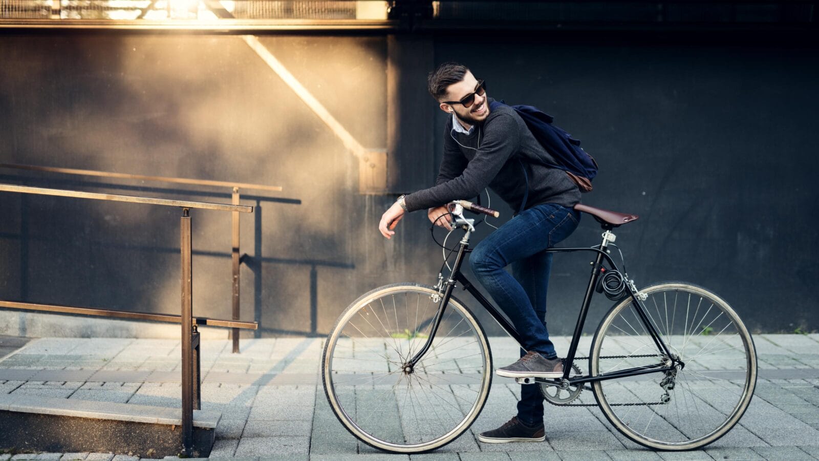A young stylish businessman going to work by bike.