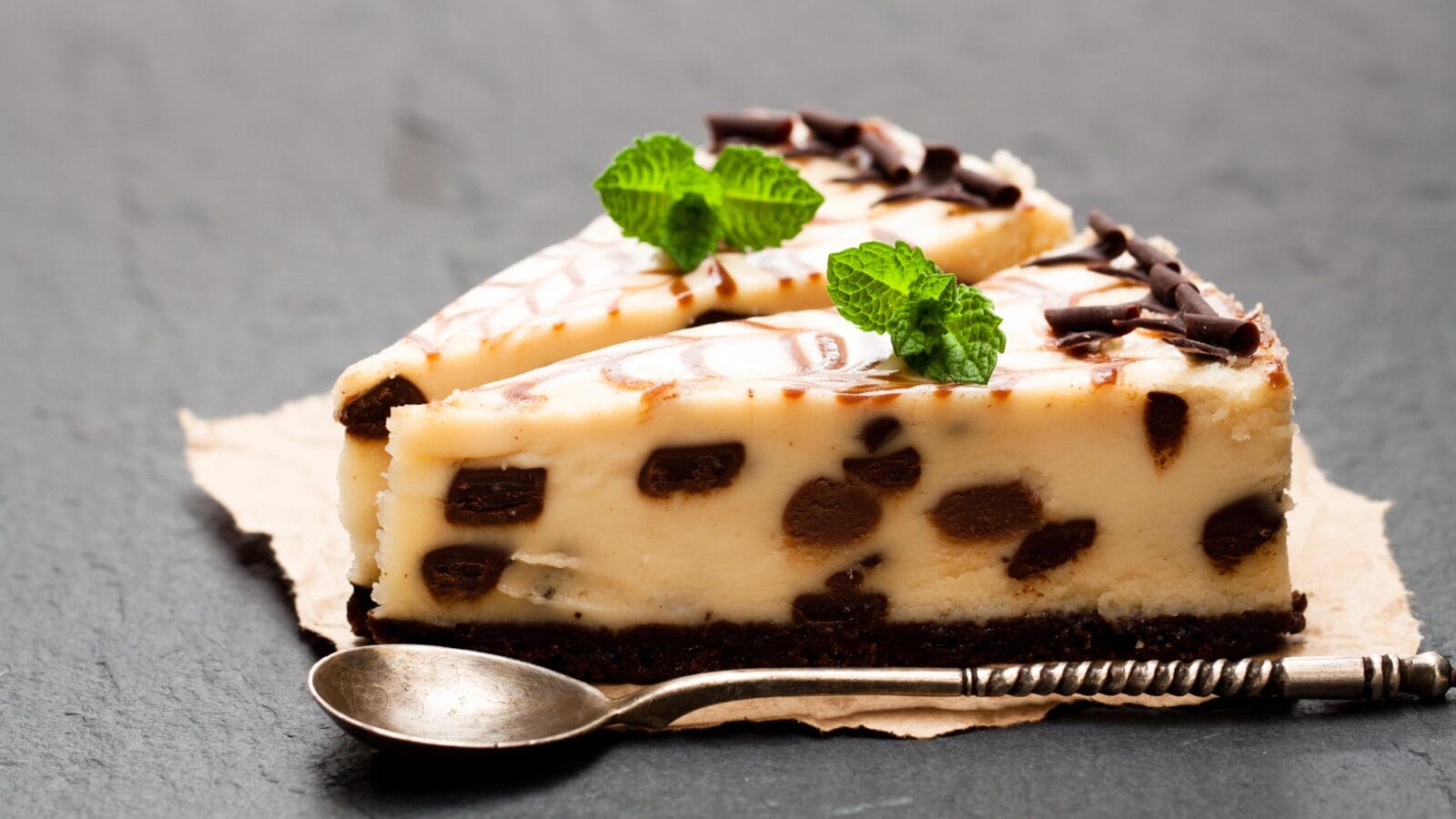 Baked white and dark chocolate cheese cake on black stone background