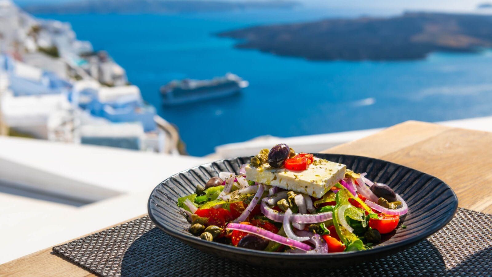 Greek salad with beautiful sea view in Santorini island, Greece.