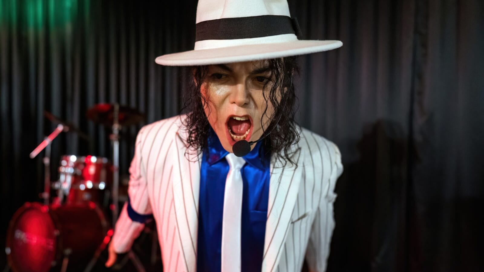 Portrait of Michael jackson wearing suit singing in a wax museum