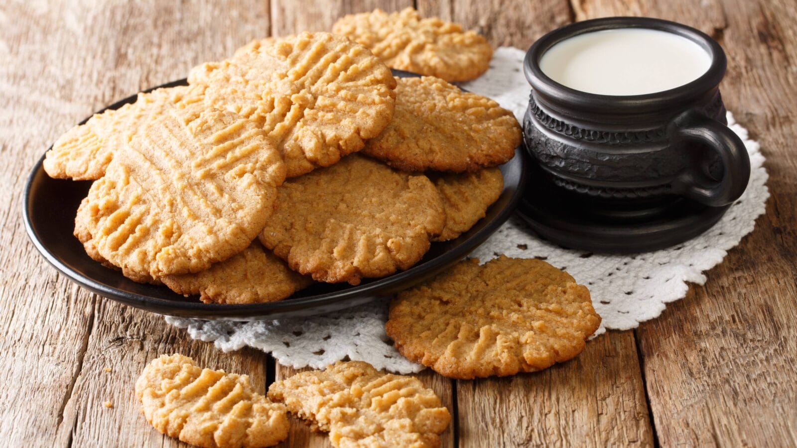 Peanut butter recipe cookies served with milk close-up on the table.