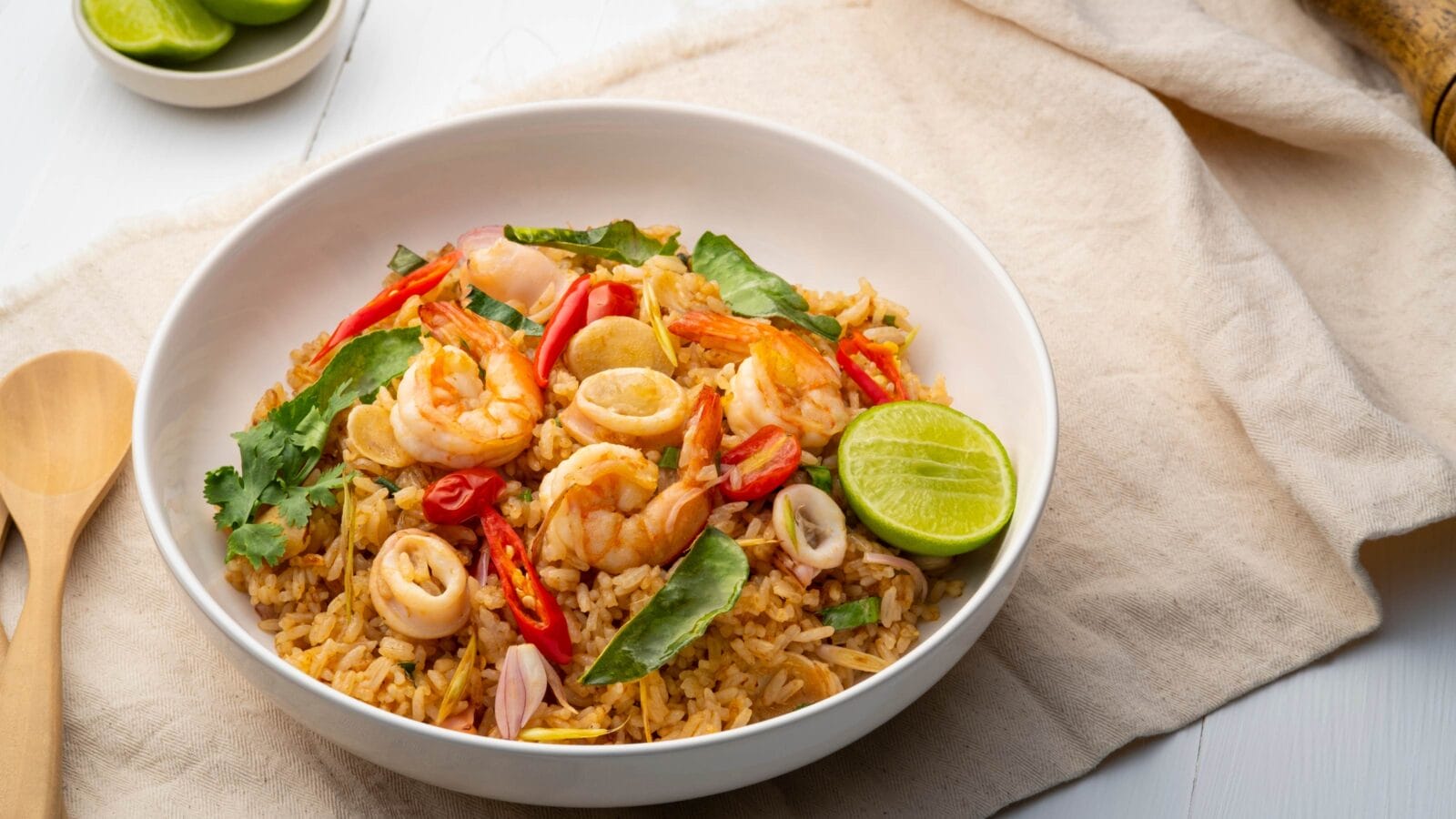 Seafood Tom Yum Fried Rice,Stir fried rice with shrimp and squid with chilli sauce on white plate