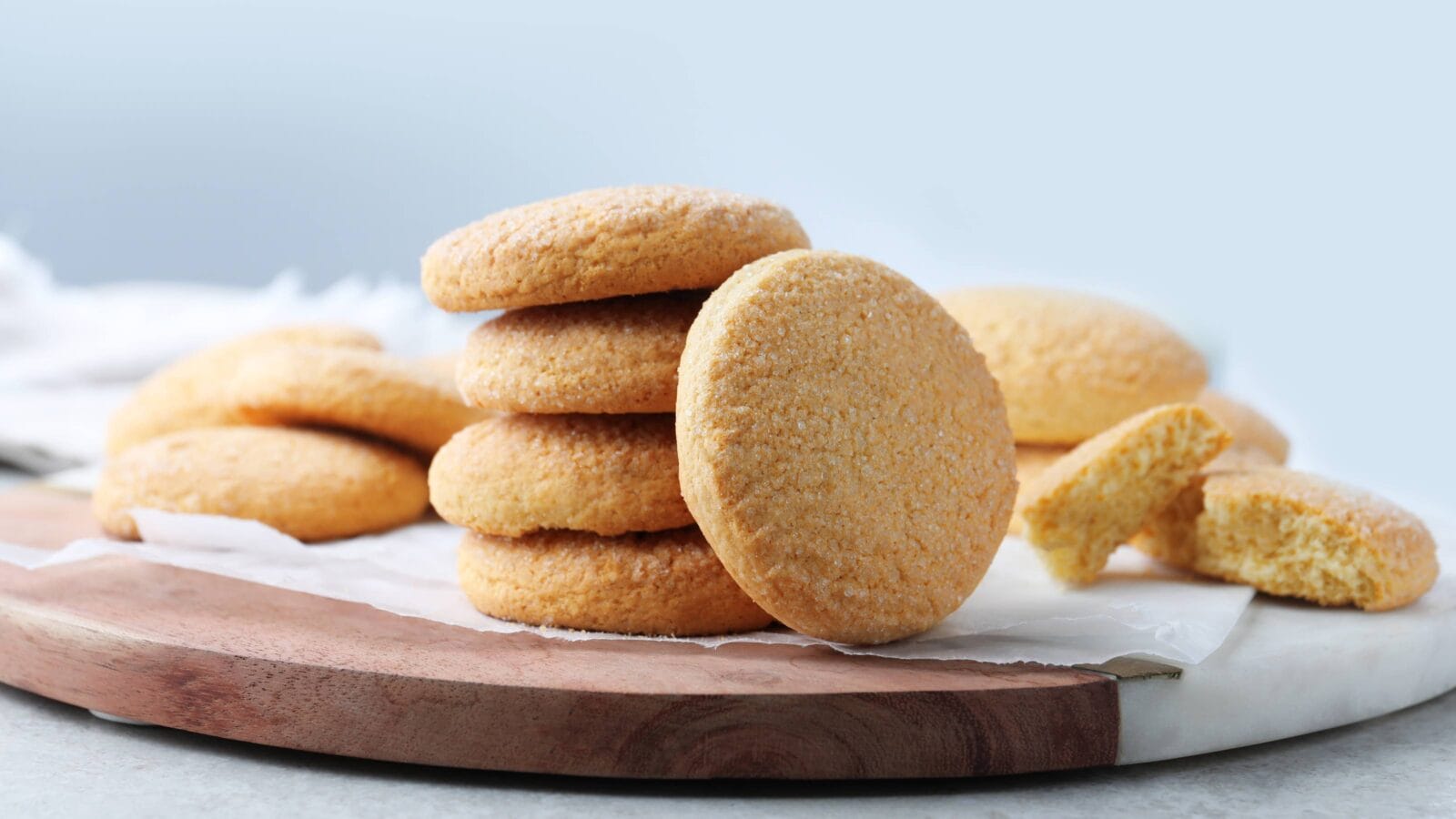 Many tasty sugar cookies on wooden board