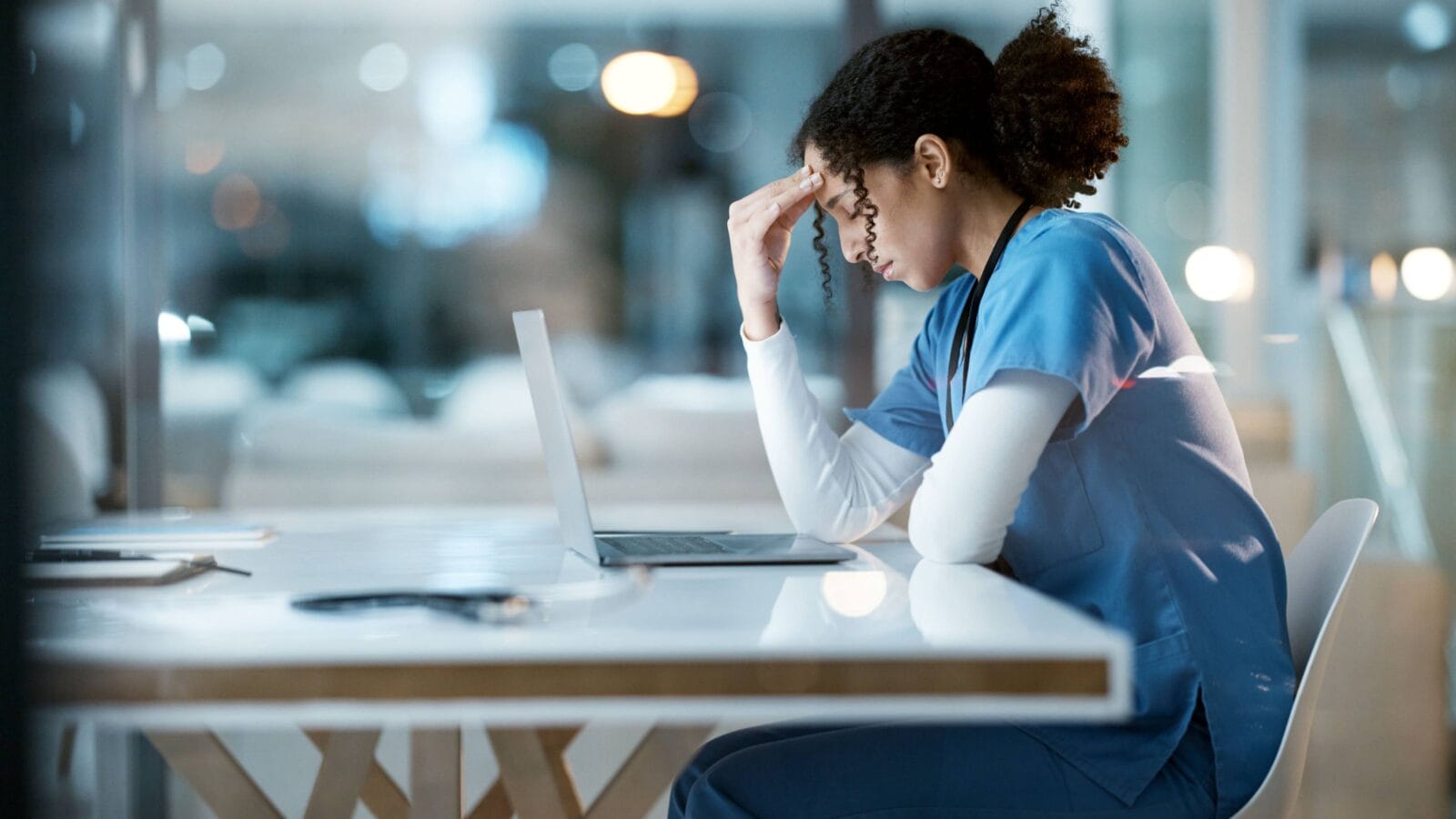 Nurse, headache stress and black woman in hospital feeling pain, tired or sick on night shift.