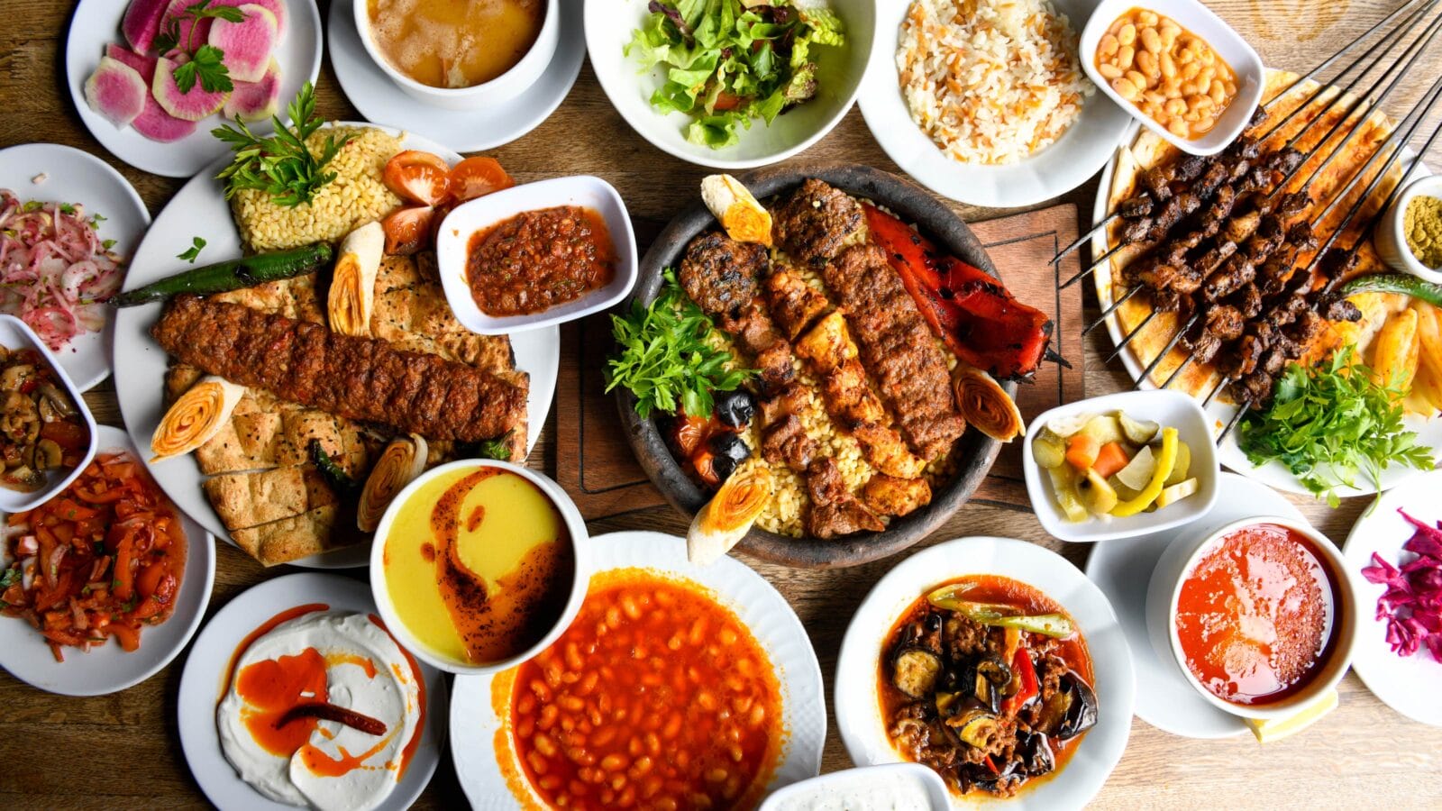 Delicious meat kebab with fresh vegetable salad served with variety of Turkish dishes and appetizers.