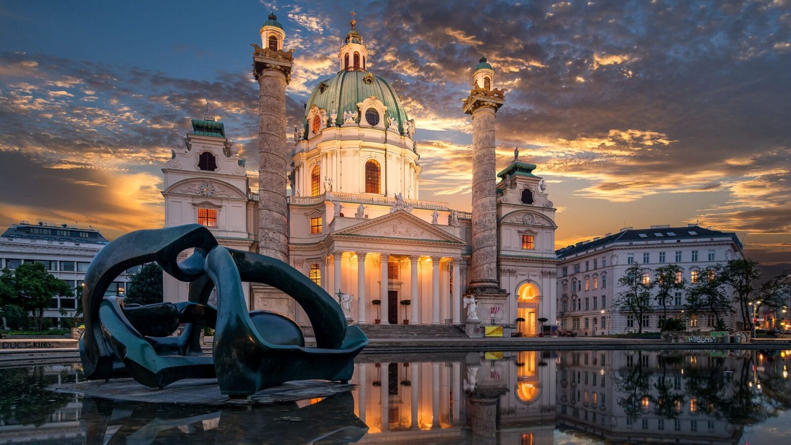 Panorama of the St. Charles Church (Karlskirche) in Vienna with sculpture and fountain during a sunset with clouds