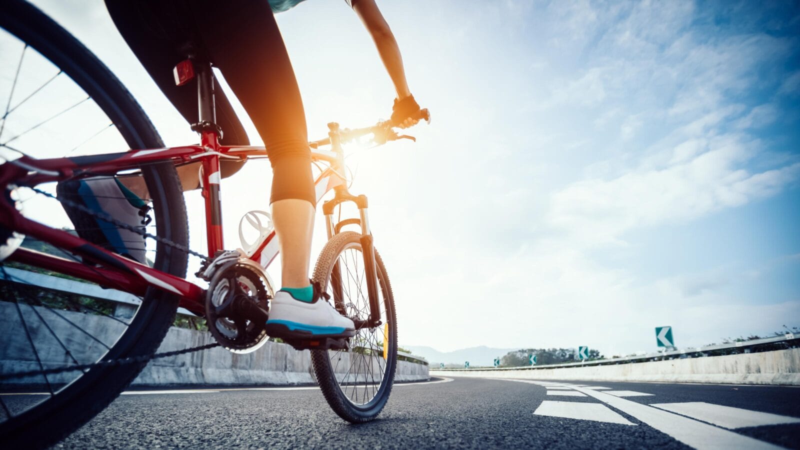 Woman cyclist legs riding Mountain Bike on highway
