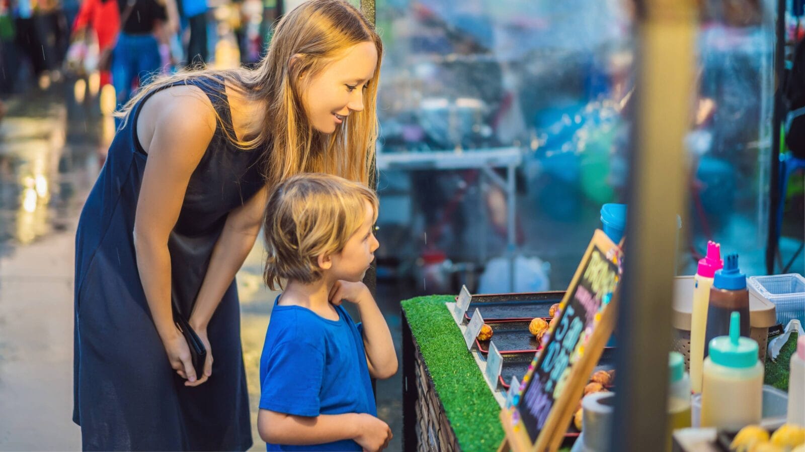 Mother and son are tourists on Walking street Asian food market