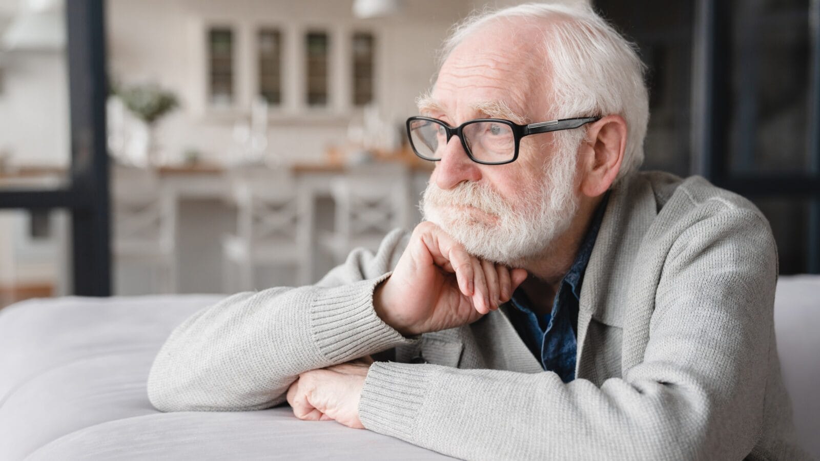 Sad tired ill sick lonely disappointed caucasian old elderly senior man grandfather sitting on the sofa couch